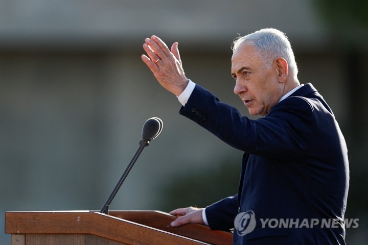 연단에서 손을 들어 올리며 연설하는 네타냐후 총리