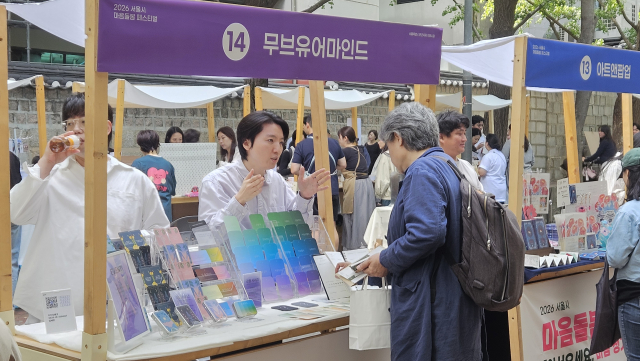 서울시 마음돌봄 페스티벌 마음 정거장 부스에서 관람객이 감정카드 소개를 듣는 모습
