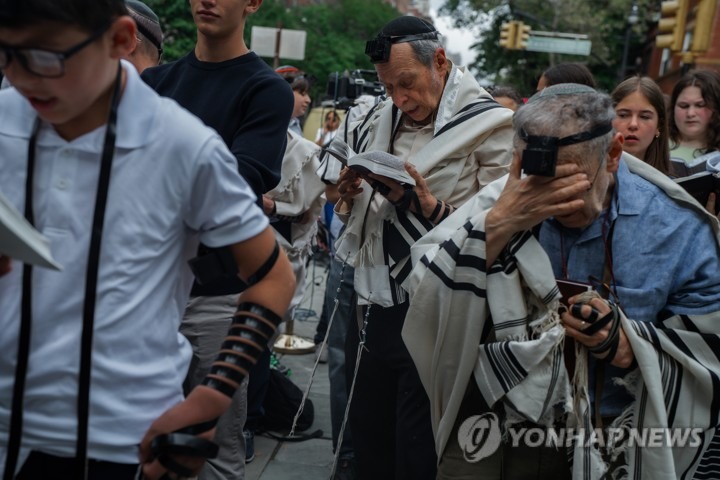 미국 뉴욕 거리에서 기도용 숄을 두른 유대인들이 기도서를 들고 기도하는 모습