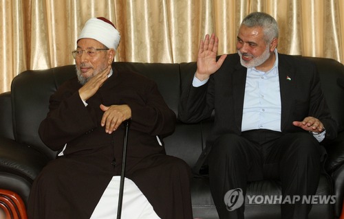 이스마일 하니야와 유수프 알카라다위가 라파 검문소에서 군중에게 손을 흔드는 모습
